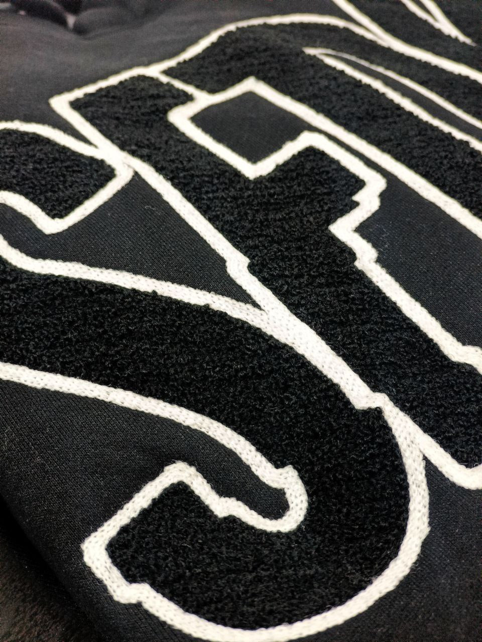 Sudadera premium negra con letras texturizadas negras "SFDK"